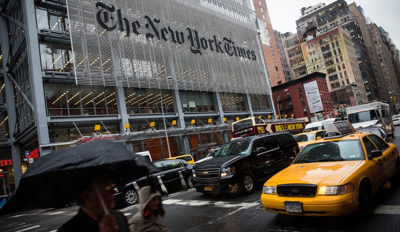 People walk past The New York Times building on Oct. 1, 2014, in New York City. The Times announced plans to cut approximately 100 jobs from the newsroom today, with the company announcing it will start with buy-out packages before moving to layoffs. (Andrew Burton/Getty Images/TNS)
