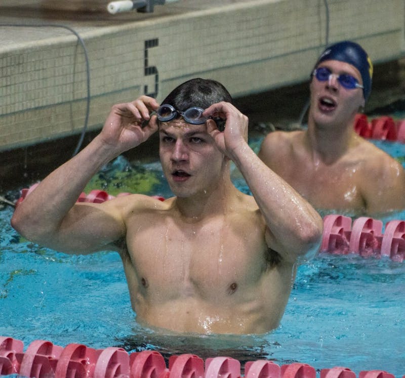 Senior Austin Green checks the scoreboard after swimming the 50m freestyle during the senior meet against Notre Dame on Feb. 4 in Lewellen Pool. Green finished second with a time of 21.34. Grace Ramey // DN