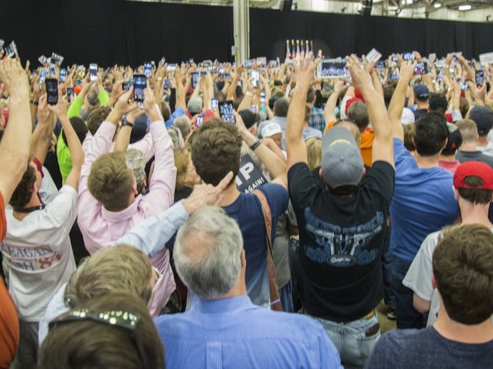 "Mixed crowds of supporters and protestors fill the Elements Financial Blue Ribbon Pavilion April 20 at a presidential rally hosting by Donald Trump in Indianapolis. Cell phones rise as Trump enters the field house to begin his speech. DN PHOTO TRENT SCROGGINS