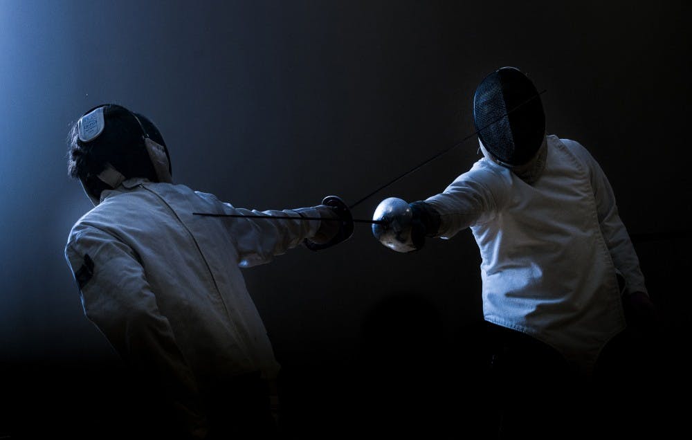 Sophomore computer science major Cole Ludwig, left, and sophomore criminal justice major Spencer Sabinske fence with sabres on Jan. 28 in the Student Recreation and Wellness Center during a fencing club meeting. DN PHOTO JONATHAN MIKSANEK