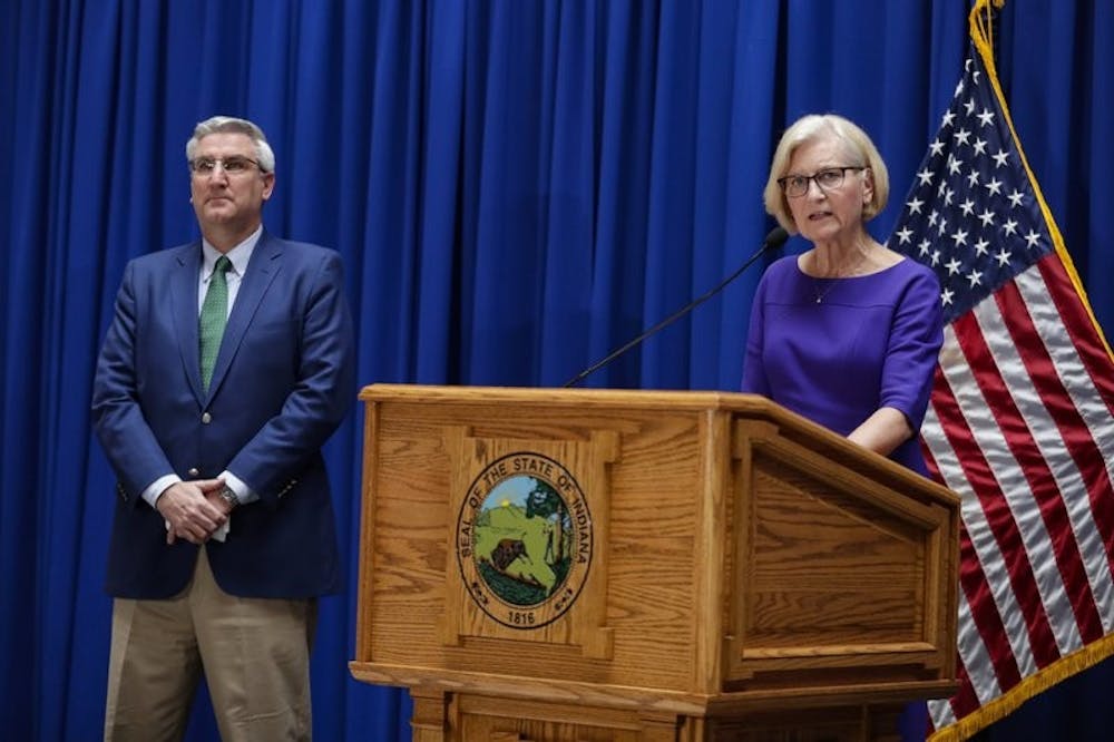 Dr. Kristina Box, Indiana Health Commissioner, answers questions about COVID-19 infections and its impact on the state as Indiana Gov. Eric Holcomb listens during a briefing at the Statehouse in Indianapolis, Tuesday, March 24, 2020. Holcomb ordered state residents to remain in their homes except when they are at work or for permitted activities, such as taking care of others, obtaining necessary supplies, and for health and safety. The order is in effect from March 25 to April 7. (AP Photo/Michael Conroy)