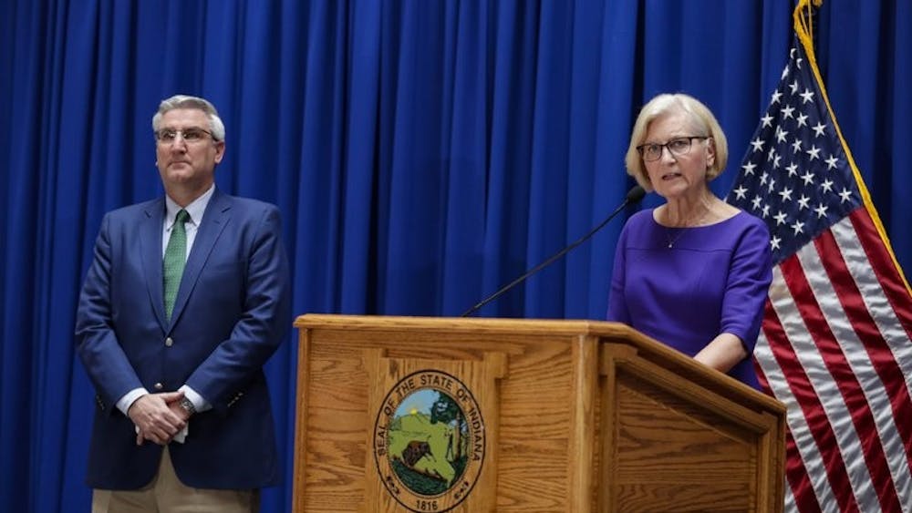 Dr. Kristina Box, Indiana Health Commissioner, answers questions about COVID-19 infections and its impact on the state as Indiana Gov. Eric Holcomb listens during a briefing at the Statehouse in Indianapolis, Tuesday, March 24, 2020. Holcomb ordered state residents to remain in their homes except when they are at work or for permitted activities, such as taking care of others, obtaining necessary supplies, and for health and safety. The order is in effect from March 25 to April 7. (AP Photo/Michael Conroy)