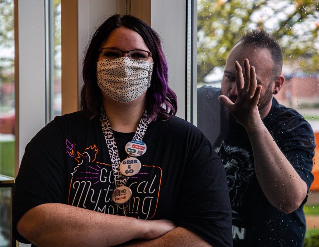Dennis Everette spies on Hannah Moody through the window April 10, 2021 at the Muncie Kennedy Library. Everette and Moody together run the Papercuts horror book club, as they both love how the horror genre shows that nothing is ever as normal as it looks. Nicole Thomas, DN
