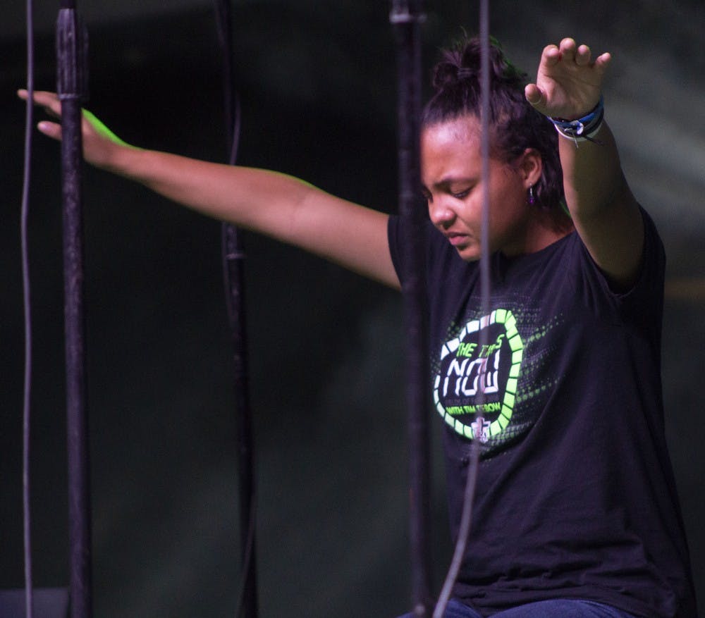 Cee Cee Pointer, a senior at Munice Central High School, stretches her hands out and sits on the stage during a song at the Fields of Faith event Nov.1, 2018, at Worthen Arena. Pointer was lead vocals for the worship team. Patrick Murphy, DN