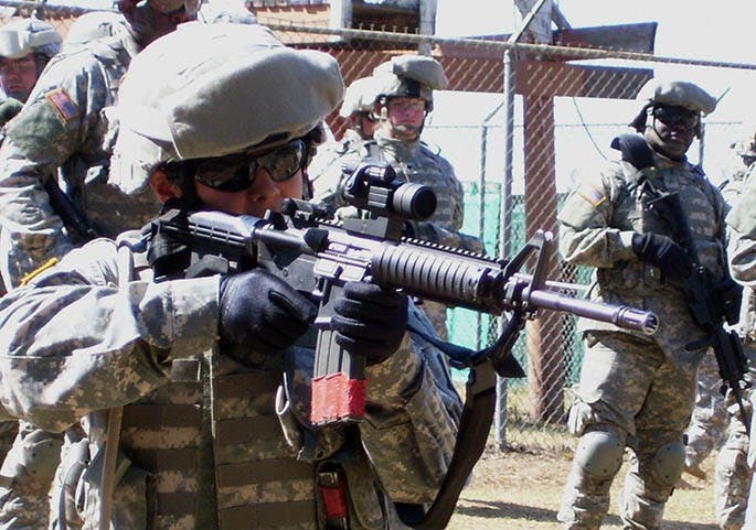 Sgt. Natalia Levesque, a combat medic from Greenville, takes aim during a reflexive fire exercise at Camp Shelby, Mississippi, March 9, 2007. About 100 of the 218th Brigade Combat Team's 1,400 soldiers training for the upcoming mission to Afghanistan are women. (Chuck Crumbo/The State/MCT)