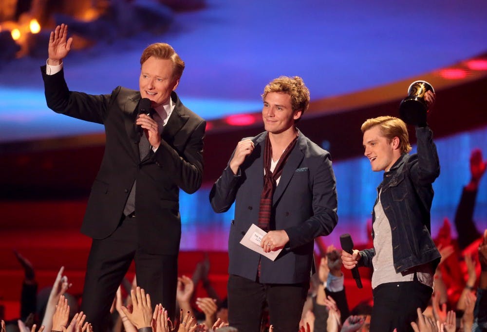 LOS ANGELES, CA - APRIL 13:  (L-R) Host Conan O'Brien with actors Sam Claflin and Josh Hutcherson, winners of the Movie of the Year award for 'The Hunger Games: Catching Fire,' speak onstage at the 2014 MTV Movie Awards at Nokia Theatre L.A. Live on April 13, 2014 in Los Angeles, California.  (Photo by Frederick M. Brown/Getty Images)