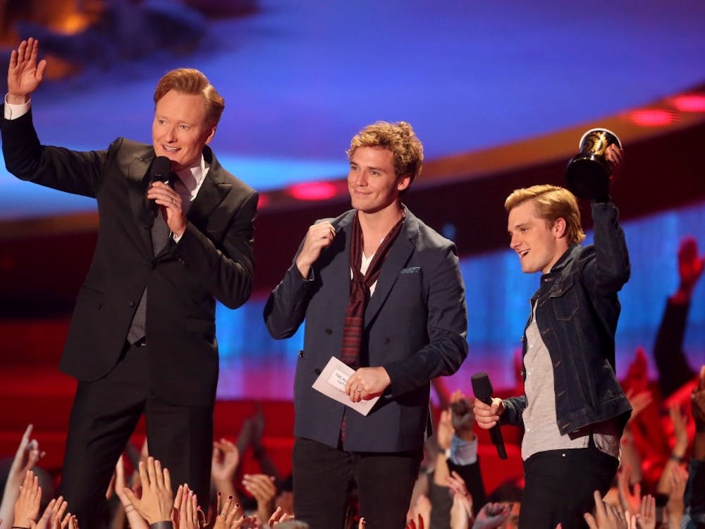 LOS ANGELES, CA - APRIL 13:  (L-R) Host Conan O'Brien with actors Sam Claflin and Josh Hutcherson, winners of the Movie of the Year award for 'The Hunger Games: Catching Fire,' speak onstage at the 2014 MTV Movie Awards at Nokia Theatre L.A. Live on April 13, 2014 in Los Angeles, California.  (Photo by Frederick M. Brown/Getty Images)