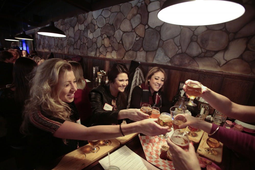 Ashley Sword, from left, Angela Wszola and Chanel Jackson toast with the other women sitting at their table during Girls' Pint Out on Thursday, Feb. 5, 2015, at Bierkeller Tavern and Eatery in Taylor, Mich. Girls' Pint Out is an all-women beer-loving organization that was founded in Indianapolis. (Tim Galloway/Detroit Free Press/TNS)