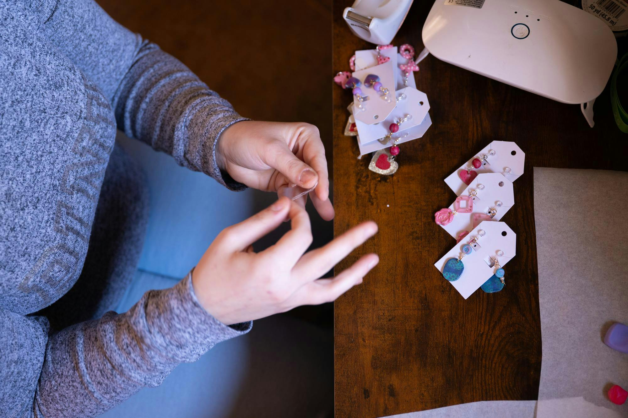 Business owner Chloe Rains ties the string the bracelet will be made on Feb. 3 in Hartford City, Ind. Kadin Bright, DN