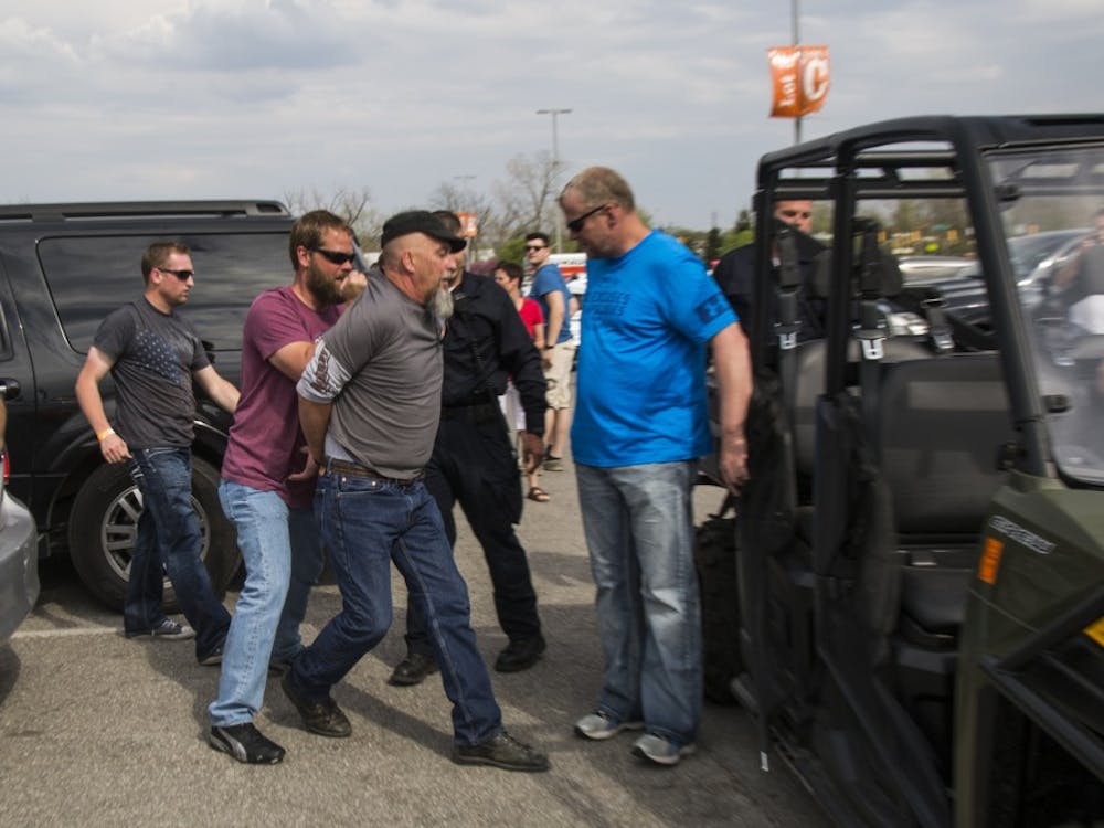 A protestor is arrested after a fight broke out in the parking lot outside a Donald Trump presidential rally at Indianapolis's fair grounds. DN PHOTO TRENT SCROGGINS