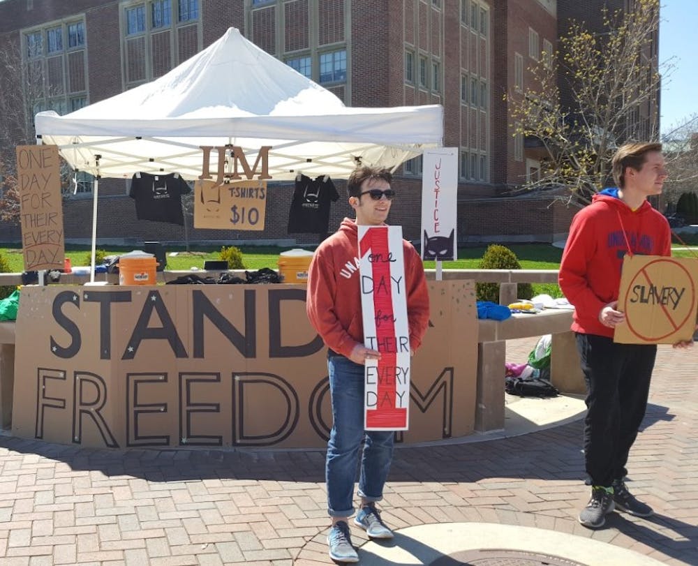 <p>Ball State International Justice Mission chapter members are standing for 24 hours at the Scramble Light for freedom. The group is bringing awareness to human trafficking from noon on April 12 to noon on April 13. <em>DN PHOTO SARA BARKER</em></p>
