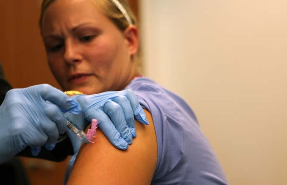 Registered nurse Dana Jakoubete, right, takes her flu shot from Sharon O'Keefe, president of Loyola University Hospital, September 2, 2009. The hospital is making all its employees get the seasonal flu vaccine. (Abel Uribe/Chicago Tribune/MCT)