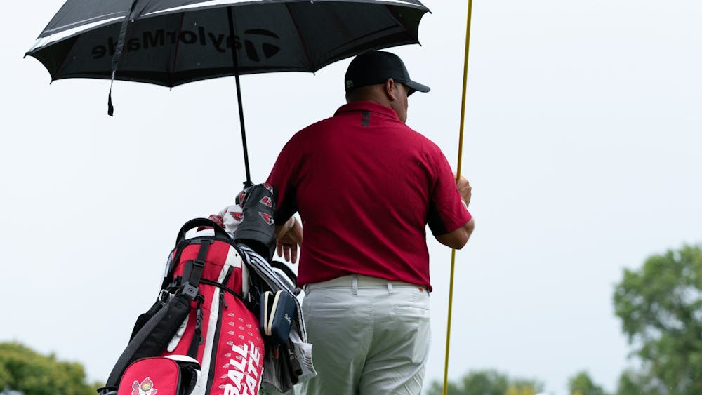 Ball State Men's Golf Head Coach Mike Fleck stands under an umbrella at hole eleven during the Earl Yestingmeier Invite Sep. 3 at the Delaware Country Club. Hosted by the Delaware Country Club, the 2022 Earl Yestingsmeire Invite had 15 teams from schools across the region competing on the par-70 course. Eli Houser, DN