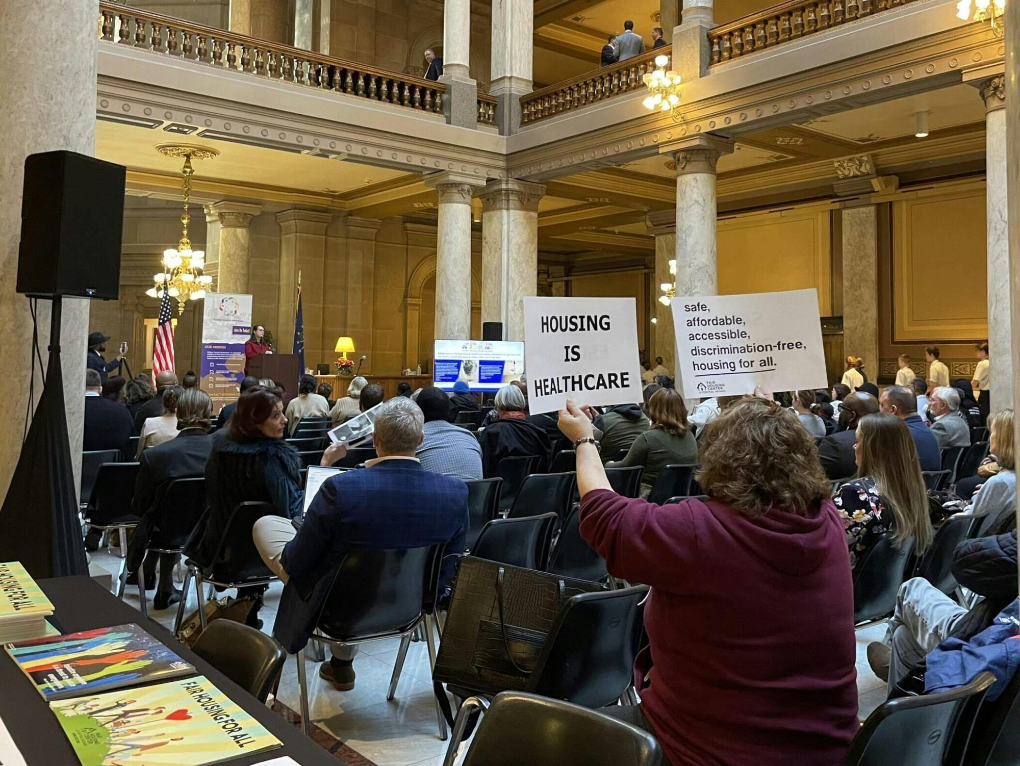 Fair Housing Center of Central Indiana leader Amy Nelson holds signs aloft at a tenants-rights rally at the Indiana Statehouse on Monday, Feb. 13, 2023. (Leslie Bonilla Muñiz/Indiana Capital Chronicle)