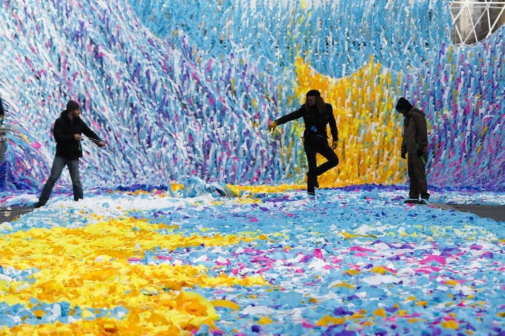 The skynet artwork 'Visions In Motion' is set to overhang the 'Strasse des 17. Juni' (Street of June 17) boulevard in front of the Brandenburg Gate in Berlin, Germany, Friday, Nov. 1, 2019. The art work by Patrick Shearn was made with about 100.000 streamers with written messages and is part of the celebrations marking the 30th anniversary of the fall of the Berlin Wall on Nov 9, 2019. (AP Photo/Markus Schreiber)