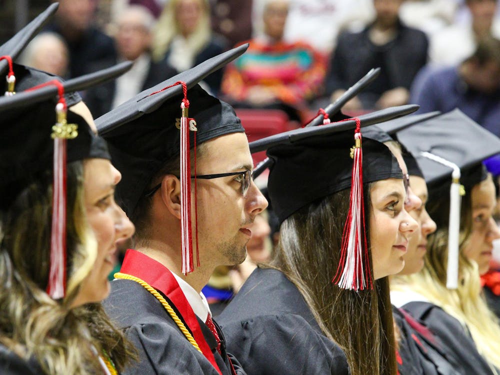 A graduate watches Trustee Emeritus Matt Mompers' commencement address at Fall Commencement Dec. 16 at Worthen Arena. Ball State conferred more than 1,200 doctoral, specialist, master’s and baccalaureate degrees during the ceremony. Daniel Kehn, DN