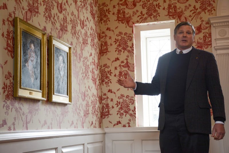 Board of Trustee member Thomas Bracken gestures to portraits of his family members in the Bracken House on March 15 during the house tour. Bracken is now suing the city of Muncie and other municipal agencies for funding for the Madjax project downtown.
