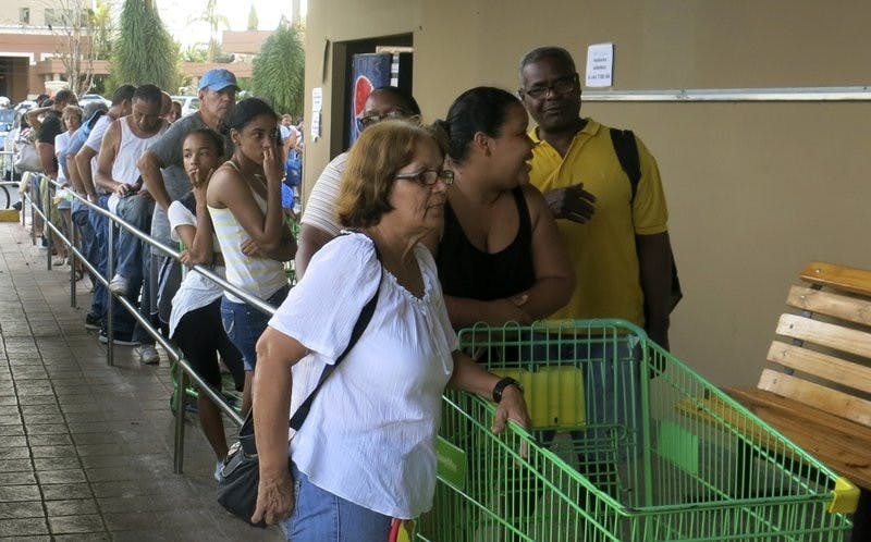People wait in line outside a grocery store to buy food that wouldn’t spoil and that they could prepare without electricity, in San Juan, Monday, Sept. 25, 2017. Most stores and restaurants remained closed Monday. Nearly all of Puerto Rico was without power or water five days after Hurricane Maria. AP Photo