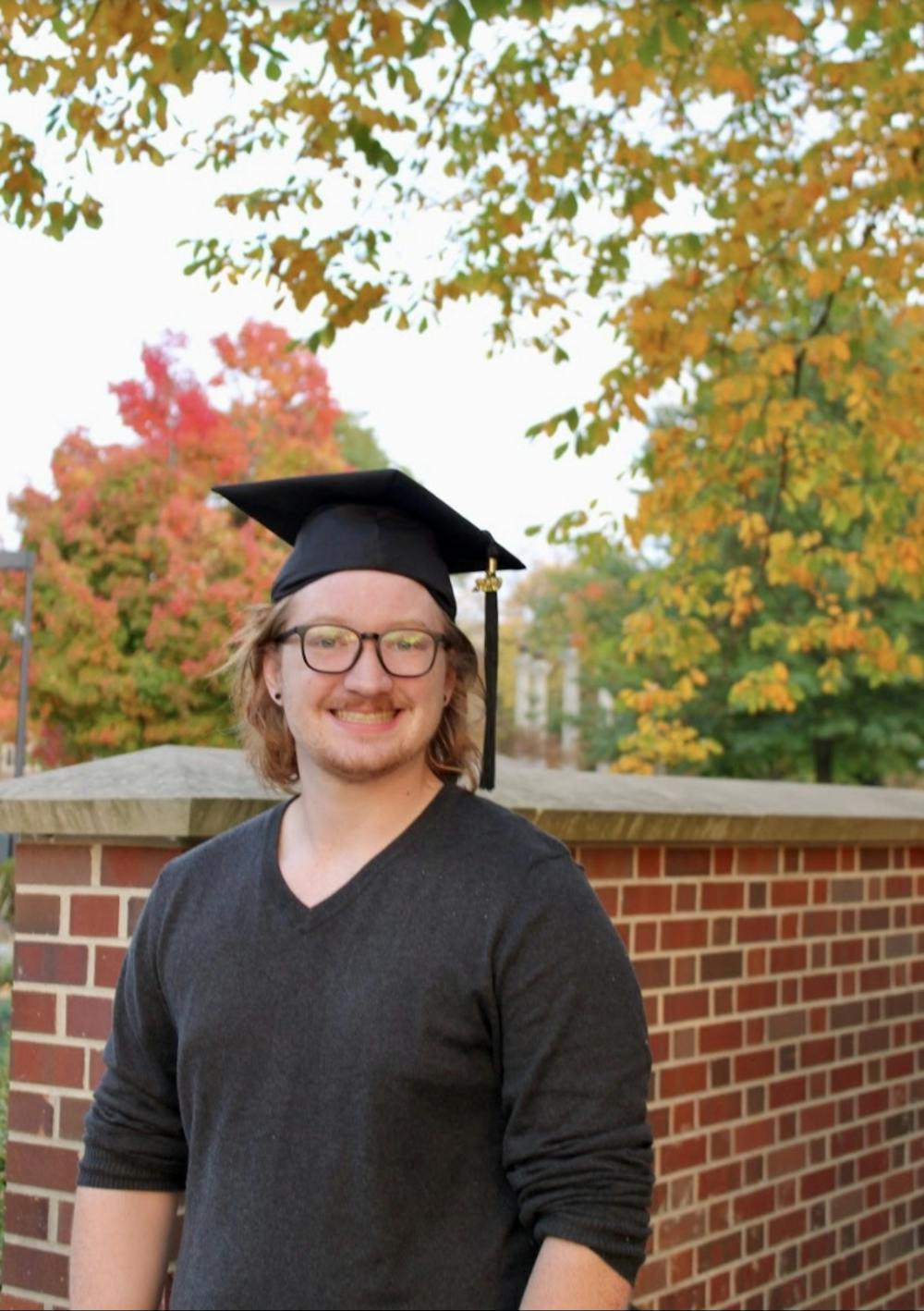 Hunter Wallace poses for a photo in his graduation cap. Wallace took a job at a software company after graduating in spring 2021, where he works from home. Hunter Wallace, Photo Provided