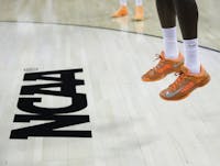 FILE - In this March 21, 2013, file photo, an athlete jumps near the NCAA logo during practice for a second-round game of the NCAA college basketball tournament in Austin, Texas. Defying the NCAA, California's governor signed a first-in-the-nation law Monday, Sept. 30, that will let college athletes hire agents and make money from endorsements — a move that could upend amateur sports in the U.S. and trigger a legal challenge. (AP Photo/Eric Gay, File)