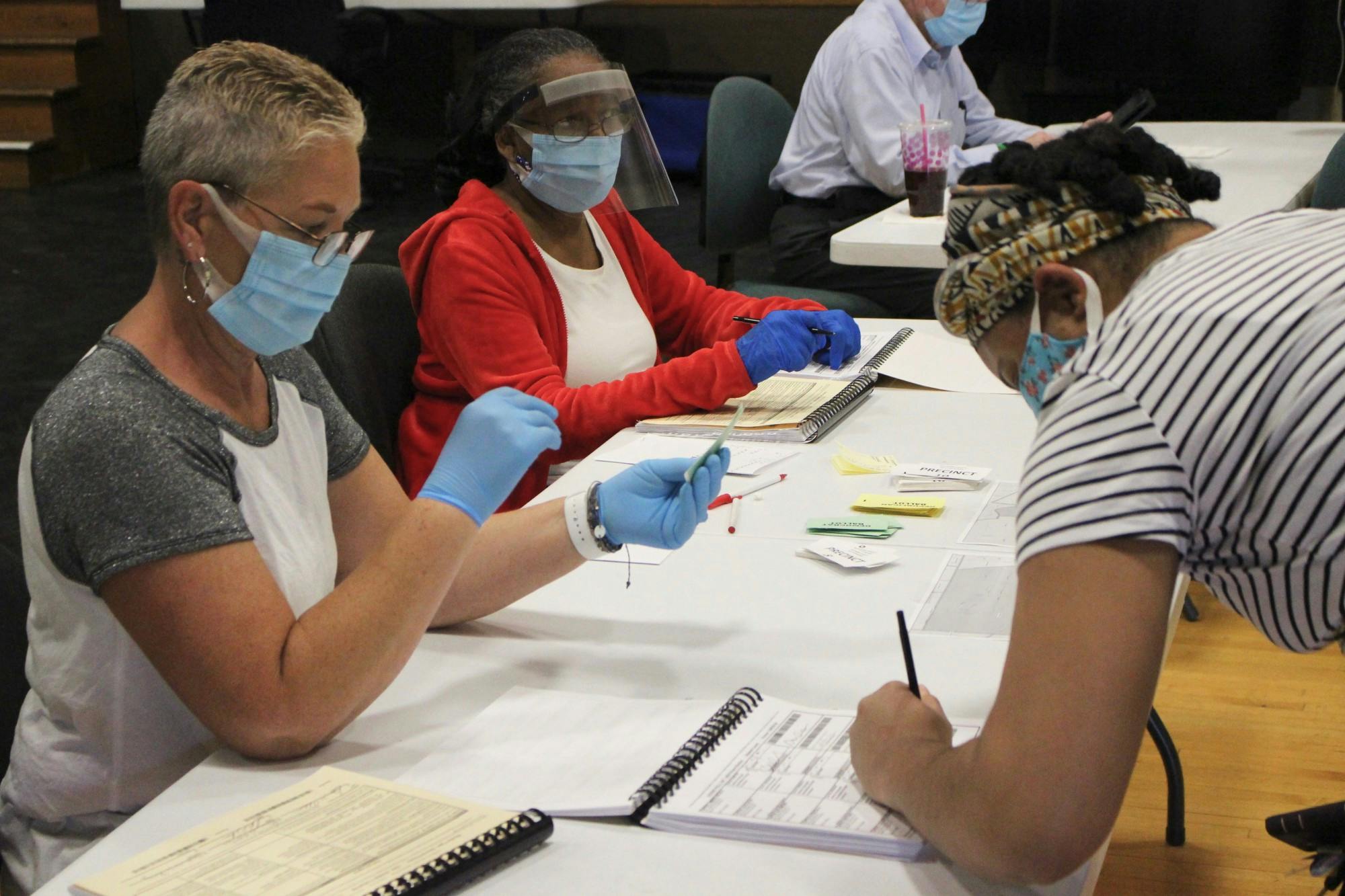 Valerie Carter, Muncie resident, signs her name to vote while election clerks Autumn Retz and Pat Akins assist her June 2, 2020, at the Oakwood building. Carter and her sister both voted at the precinct a few minutes apart. Bailey Cline, DN