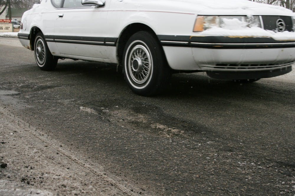 A car narrowly misses a two-inch deep pothole Feb. 4 on Wheeling and Neely avenues. Donnie Wright, supervisor for the city