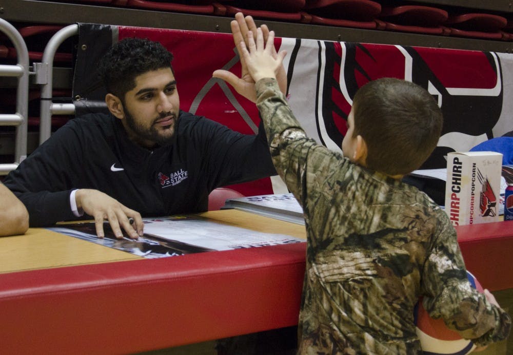 Men's basketball player Bik Gill high fives Nathan Grunkemeyer, 5, at the Winter Fan Jam on Jan. 4 at Worthen Arena. DN PHOTO BREANNA DAUGHERTY
