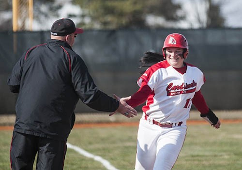 Head coach Craig Nicholson congratulates Taylor Rager as she rounds third after her home run against Northern Illinois. DN PHOTO JONATHAN MIKSANEK