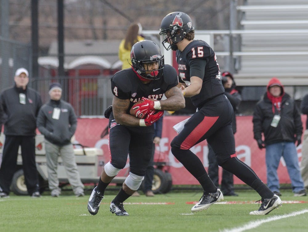 Redshirt sophomore quarterback Ozzie Mann hands the ball to redshirt junior running back Horactio Banks during the game against Eastern Michigan on Nov. 22 at Scheumann Stadium. DN PHOTO BREANNA DAUGHERTY