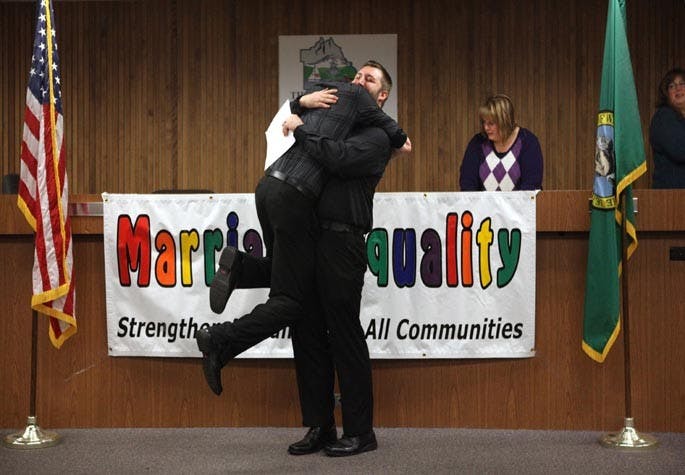 Rory Smallwood, left, leaps into the arms of his partner, Joey Summerson, after the pair received their marriage license during ceremonies at the Thurston County Courthouse shortly after midnight on Thursday, December 6, 2012. (Tony Overman/The Olympian/MCT)