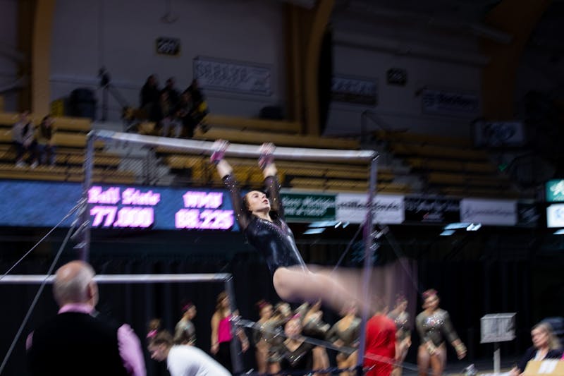 A Western Michigan gymnast performs her uneven parallel bar routine against Ball State Feb. 9, 2020, at Read Fieldhouse in Kalamazoo, Michigan. The Broncos beat the Cardinals 195.750-193.675. Jacob Musselman, DN