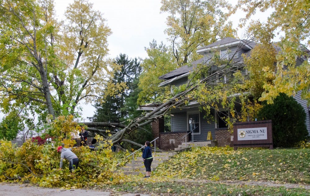 Students help move branches out of the Sigma Nu Theta Nu Chapter on Beachwood Avenue. Thousands of residents lost power after a brief EF-1 tornado touched down in Muncie Sunday. Power is still being restored and damage is still being assessed. Mary Freda, DN