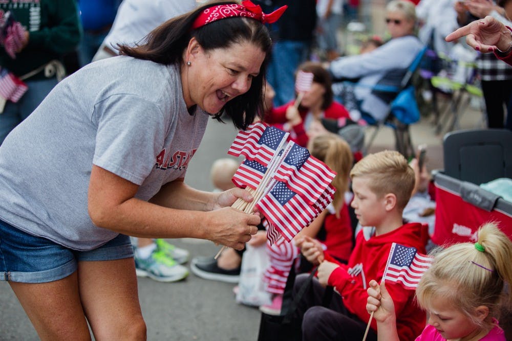 Small American flags were given out to parade goers at Ball State's Homecoming parade Oct. 21, 2017. The parade this year will be limited to 100 floats and will commemorate the university's centennial Oct. 20, 2018. Reagan Allen, DN