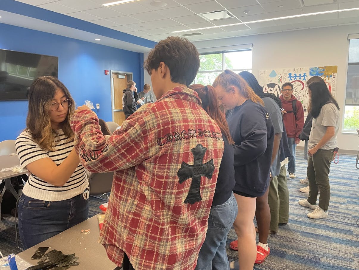 Karina Stoltz, president of the Japanese Culture Club, teaches members to shape onigiri.

Radley Richman, NewsLink Indiana