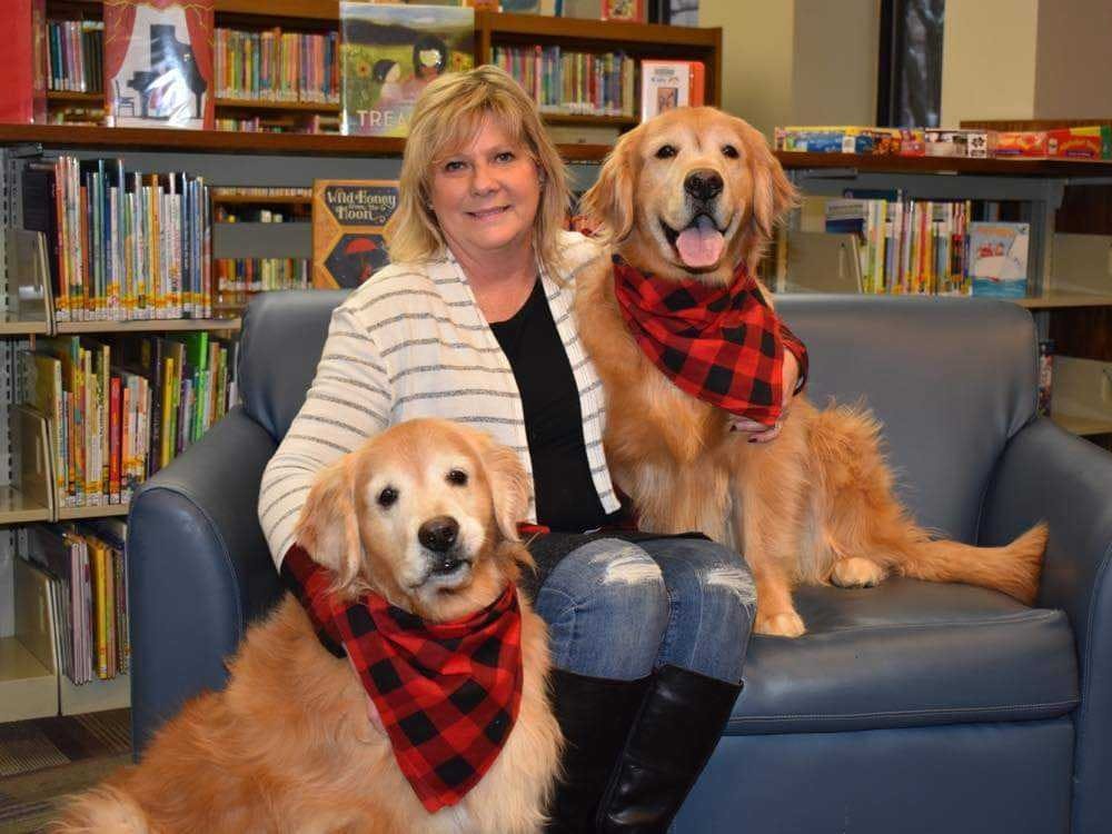 Cindie Hudson sits with her therapy dogs, Harlee and Seger, at the Kokomo-Howard County Public Library. Hudson recently published a children's book called "Yellow Dog" in an effort to encourage children to read. Cindie Hudson, Photo Provided