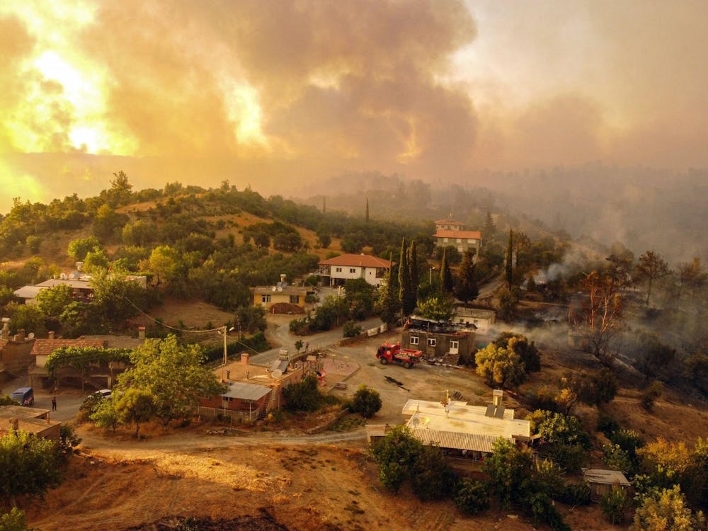 This aerial photograph shows houses surrounded by a wildfire which engulfed a Mediterranean resort region on Turkey's southern coast near the town of Manavgat, on July 30, 2021. (AFP/Getty Images/TNS)