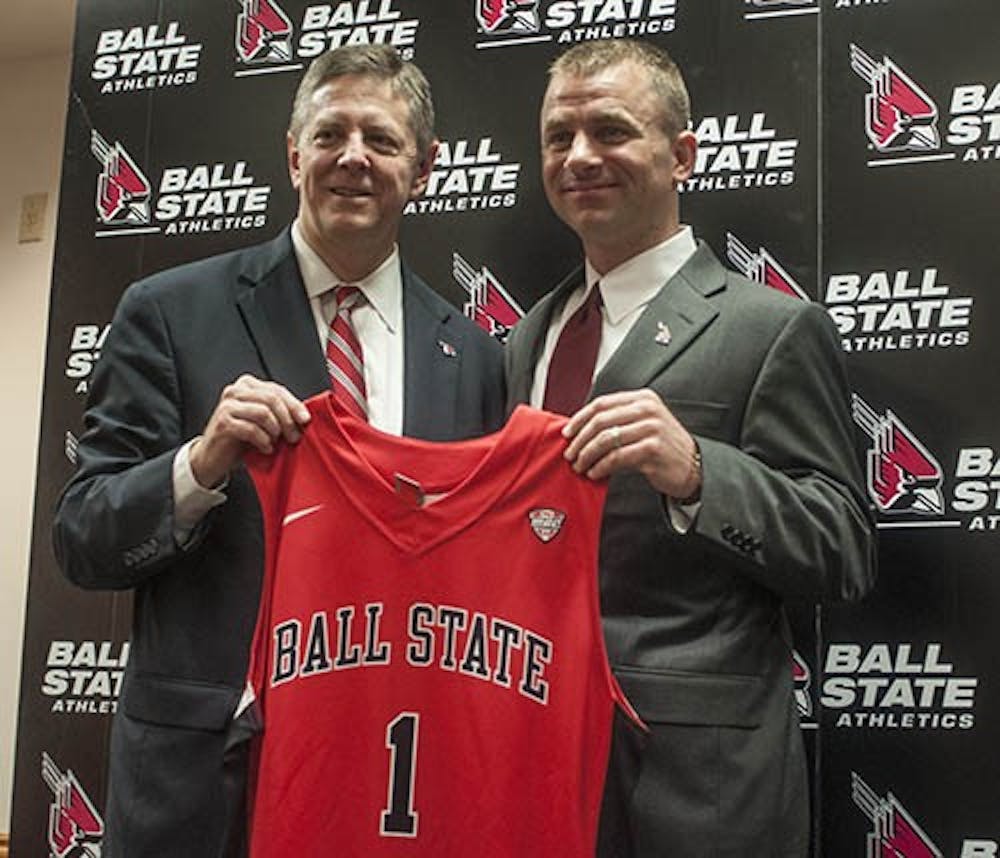 Athletic director Bill Scholl and men's basketball head coach James Whitford pose for a photo holding an honorary jersey given to Whitford. Whitford was named head coach to replace Billy Taylor for the 2013-14 season. DN PHOTO JONATHAN MIKSANEK