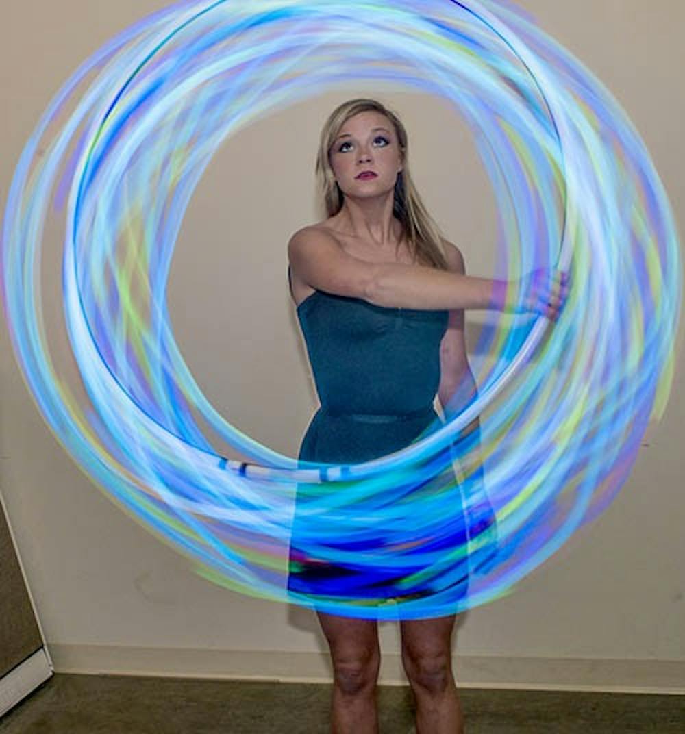 Junior public relations major Jessica McIntosh shows off her skills with her LED hula hoop March 25. McIntosh practices around campus in areas such as the Worthen Arena concourse. DN PHOTO EMMA FLYNN