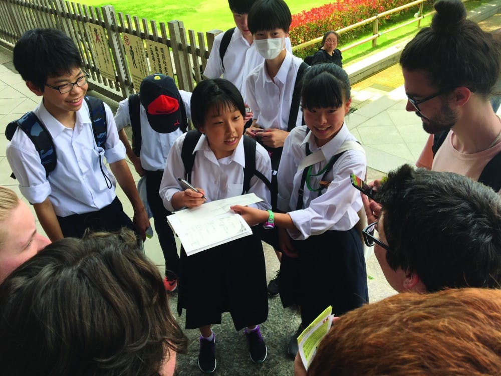 <p>Japanese students run up to interview CAP Japan study abroad students James Kohlmeyer, Taylor Henderson, Camden Hochgesang and Jesse Lindenfeld at The Great Buddha Hall in Nara, Japan. By interviewing, the children practiced their language skills and learned to interact with foreigners. <strong>Miguel San Miguel, Photo Provided.</strong></p>