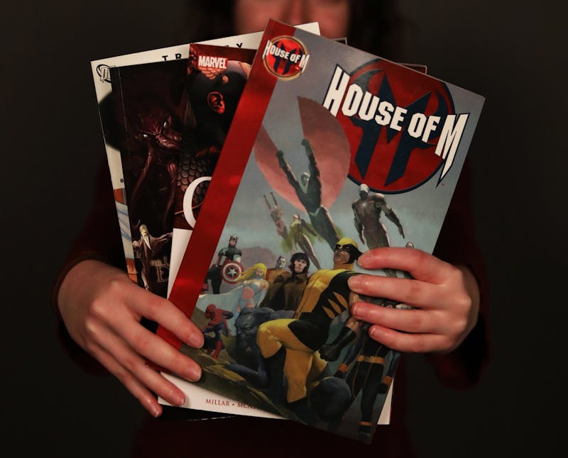 Sophomore journalism major, Emily Hunter holds several of her favorite comic books, March 23, 2021, in the photojournalism studio. Rylan Capper DN 