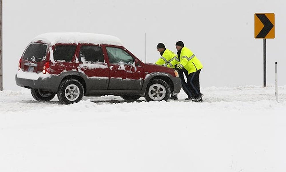 KDOT safety workers push a stranded car off of the northbound ramp to I-235 from Zoo Blvd., Thursday, February 21, 2013, in Wichita, Kansas. A major snowstorm lashes U.S. Great Plains as it heads east. (Bo Rader/Wichita Eagle/MCT)