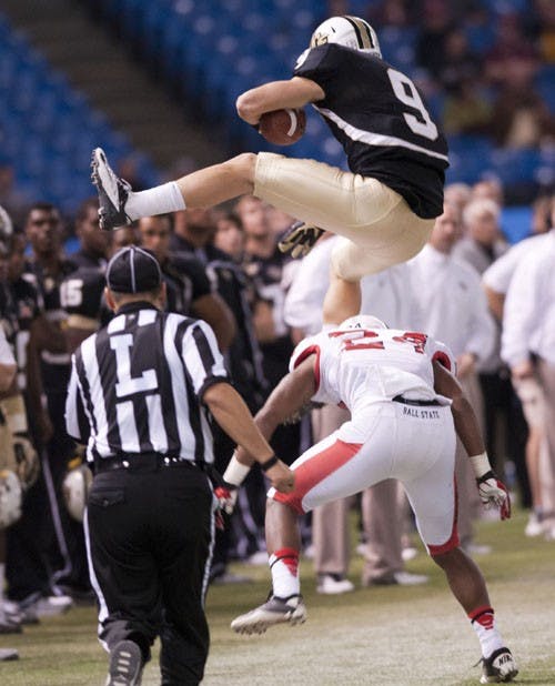 Central Florida's J.J. Worton vaults over Ball State's Jeffery Garrett for a first down. DN PHOTO BOBBY ELLIS