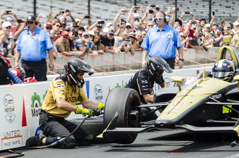 Brendon Cleave, damper engineer for Arrow Schmidt Peterson Motorsports, quickly changes a tire on Marcus Ericsson's car during the pit stop challenge May 24. Arrow SPM won $50,000 after beating Scott Dixon's time of 13.132 seconds. Stephanie Amador, DN