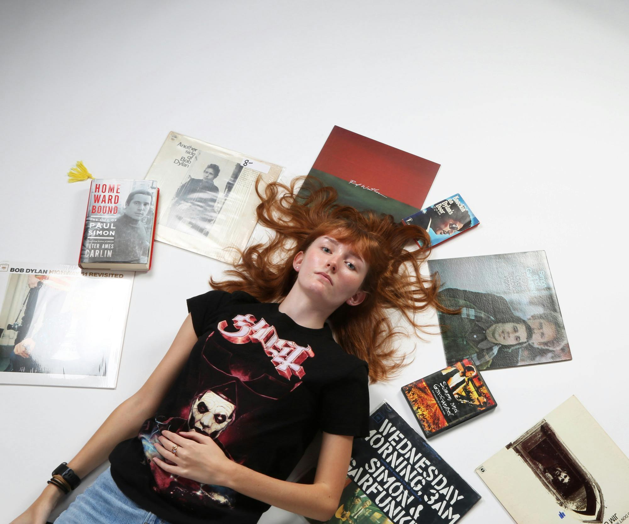 Opinion editor and second-year journalism major Kate Farr poses for a photo surrounded by some of her favorite music items while wearing a Ghost tour T-shirt Sept. 25 in the photojournalism studio. Mya Cataline, DN