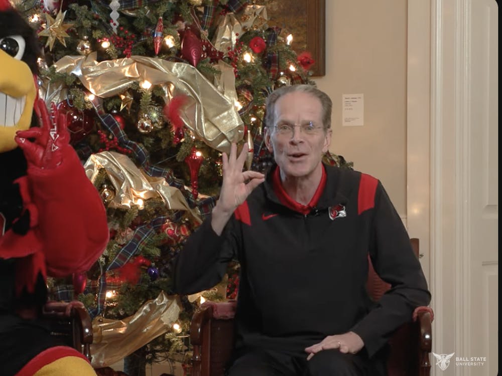 Ball State University President Geoffrey Mearns holds up a 'chirp, chirp' sign with Charlie Cardinal in a YouTube video inside Bracken House. Mearns confirmed in the video, which published Dec. 13, that he had dislocated his left ankle and fractured it in three places over Thanksgiving Break. Ball State Marketing and Communications, courtesy