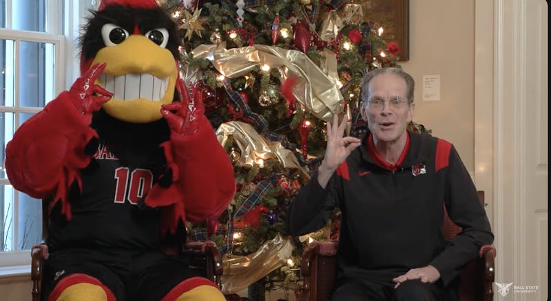 Ball State University President Geoffrey Mearns holds up a 'chirp, chirp' sign with Charlie Cardinal in a YouTube video inside Bracken House. Mearns confirmed in the video, which published Dec. 13, that he had dislocated his left ankle and fractured it in three places over Thanksgiving Break. Ball State Marketing and Communications, courtesy