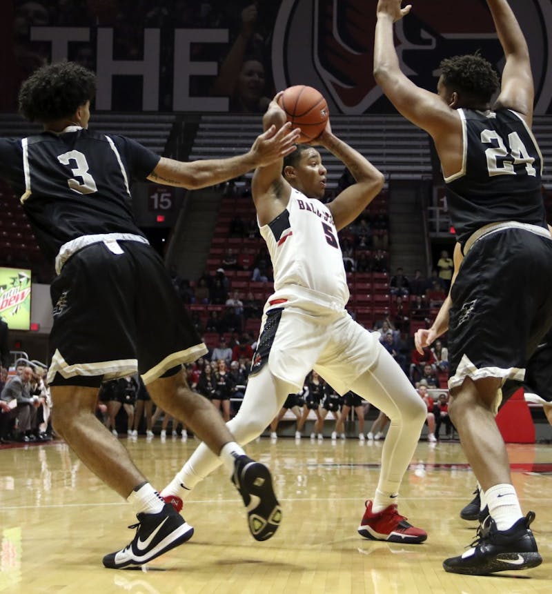 Ball State sophomore guard Ishmael El-Amin tries to find an open teammate while being guarded by the University of Indianapolis' Marcus Latham (3) and Radwan Bakkali (24) during the Cardinals' exhibition game against the Greyhounds Nov. 2, 2018, in John E. Worthen Arena. Ball State won 92-76. Paige Grider, DN