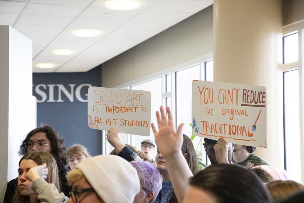 Students hold up signs during a gathering in front of the administration offices on the fourth floor of the Art and Journalism building on March 28. The gathering took place in response to changes happening in the School of Art. Olivia Ground, DN