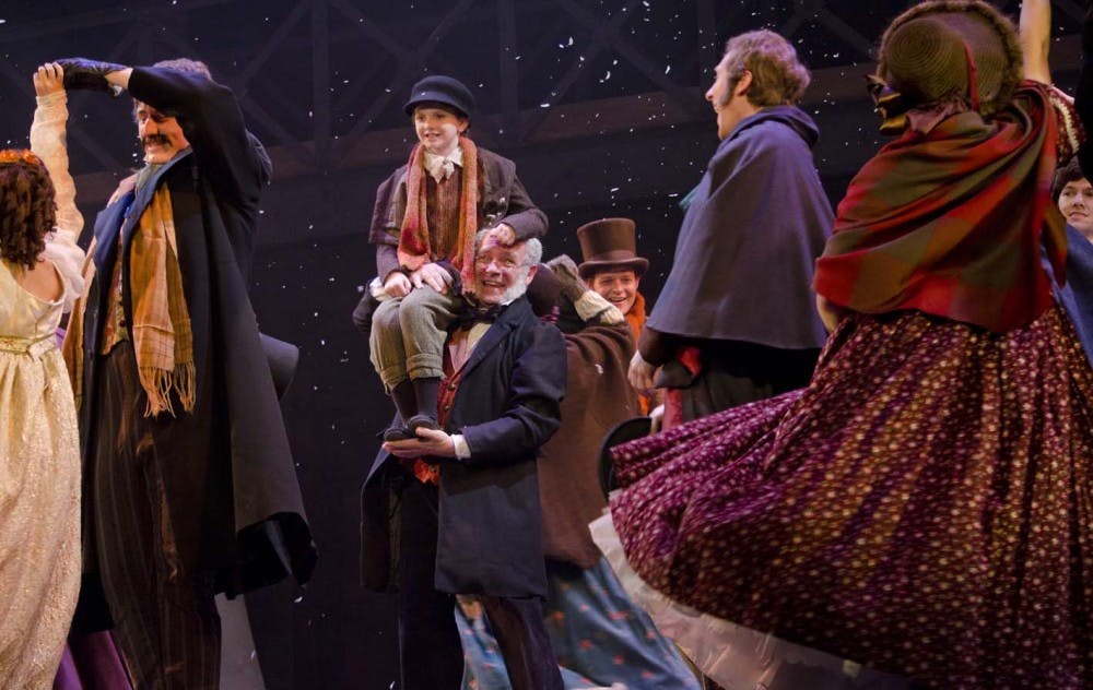 Ebenezer Scrooge, played by Peter Zapp, holds Tiny Tim, who is played by Gracie Evans. The two embrace after Scrooge become a new man. DN PHOTO COREY OHLENKAMP