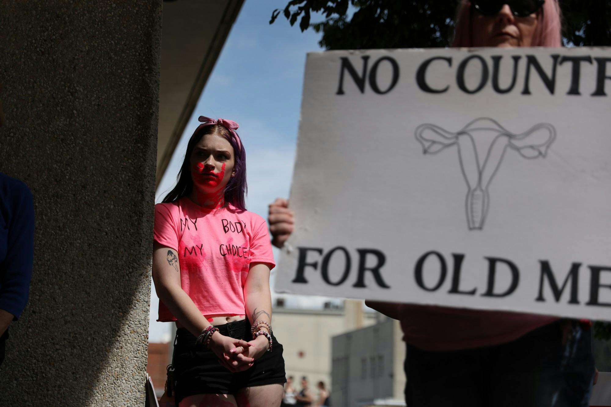 Dani Thompson leans against a pillar at the "Bans Off Our Bodies" march May 14 in Downtown Muncie. The march was hosted by the non-profit group Women's March. Rylan Capper, DN